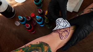Tattoo-artist-using-tattoo-transfer-paper